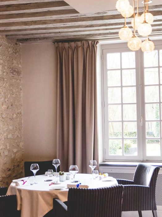 Table dans un angle intimiste du restaurant, idéale pour célébrer un anniversaire en famille, baigné par la lumière naturelle