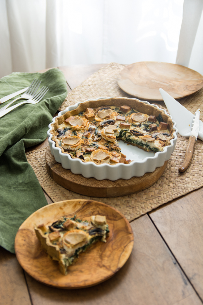 Part de tarte au chèvre et aux épinards, à déguster chaud ou froid, dans des assiettes en bois ramenée du Sud de la France