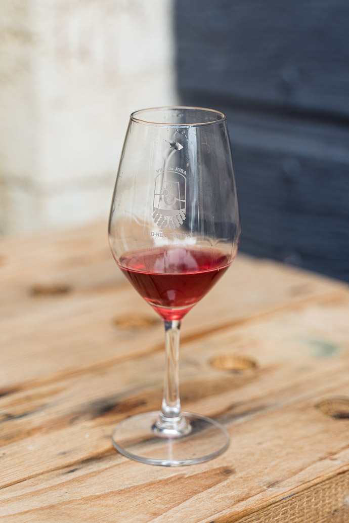 Un verre de Poulsard à la robe rubis clair, vin du Jura