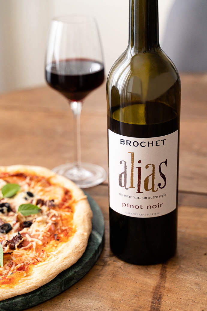 Recette de pizza au speck, base tomates olives & câpres, mozzarella et basilic - accompagné d'un délicieux vin de Loire 100% Pinot Noir Amplidae ALIAS