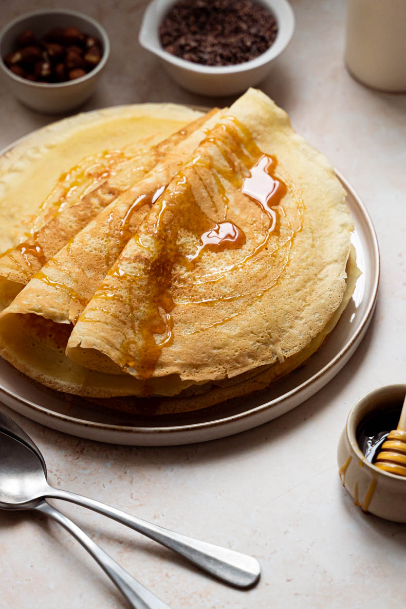 Nappez vos crêpes de la Chandeleur avec du miel, quelques noisettes et du grué de cacao pour une garniture originale 